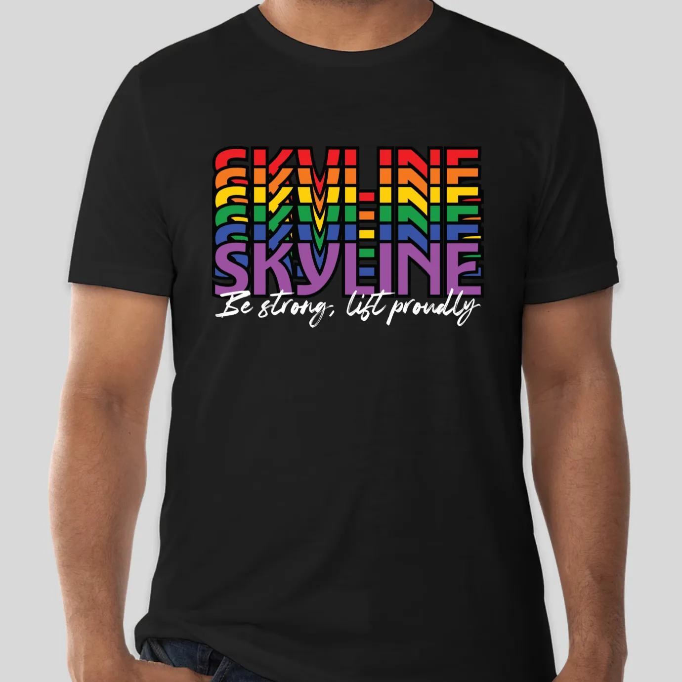 A rainbow Skyline "be strong, lift proudly" design on a black tee.